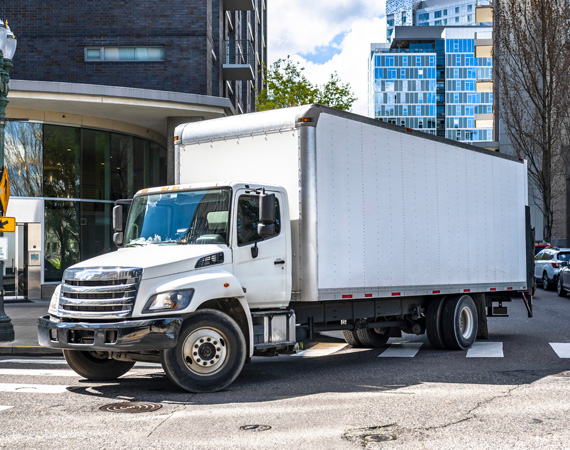 White medium size truck driving in city 1.jpg