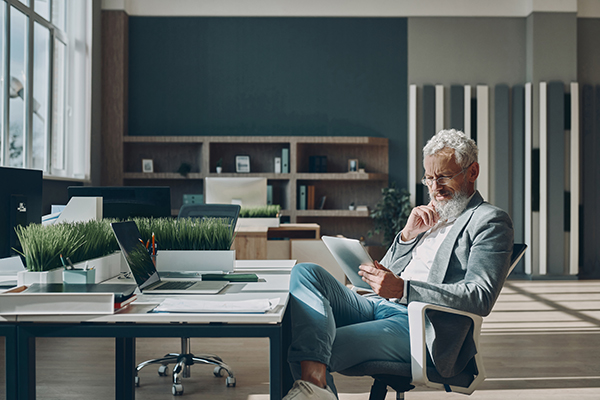 confident mature businessman using digital tablet