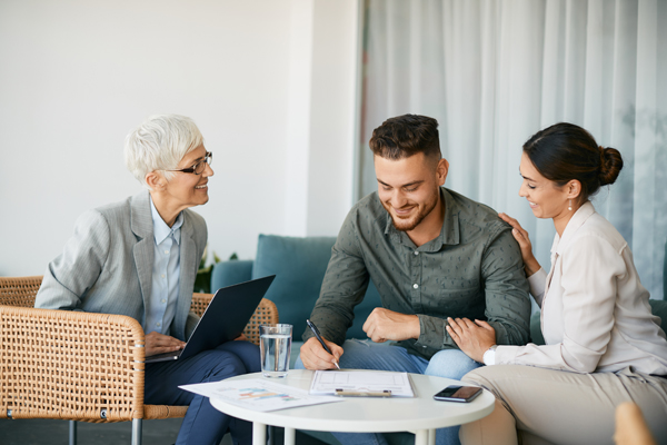 happy couple signing a contract with financial advisor