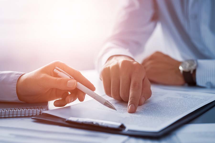 pointing to paperwork on a desk