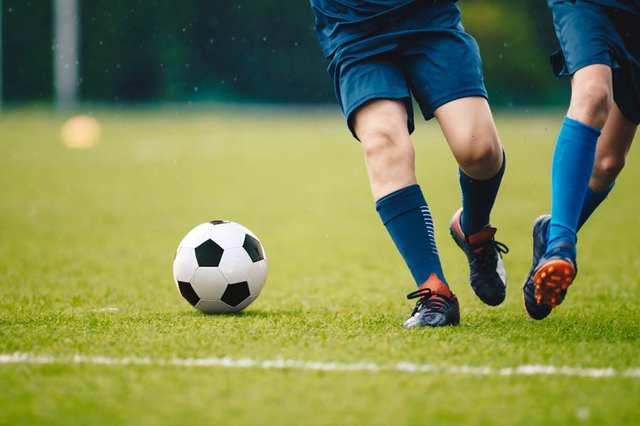 two soccer players on the pitch with a soccer ball