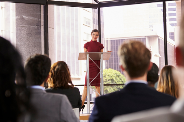 young woman standing at lectern presenting